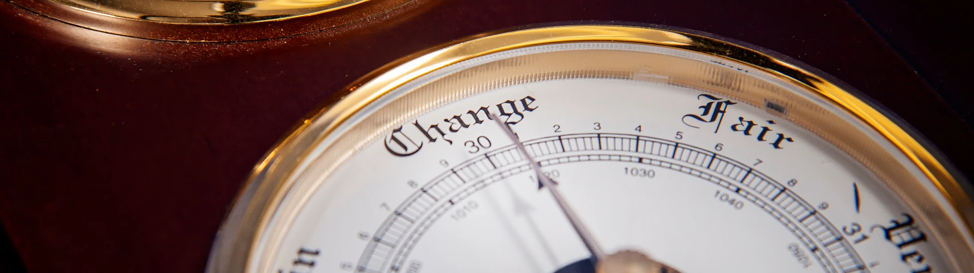 Close-up: Vintage wood/brass weather station shows a barometer face with 'Change, Rain, Fair' below a clock face.