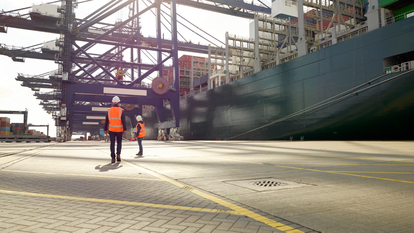 Dock workers beside cargo ship at Port of Felixstowe, England image