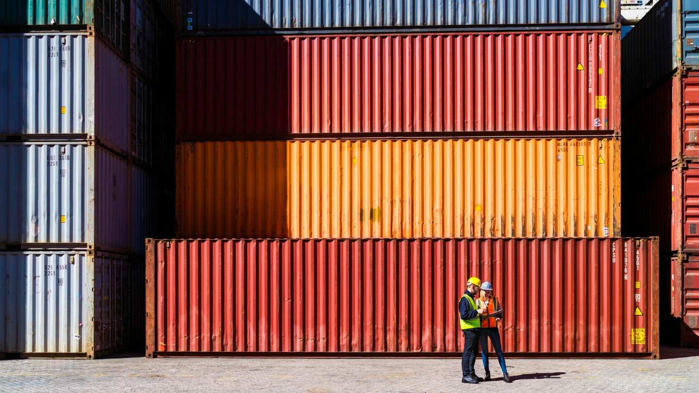 Two workers having a conversation about containers Two workers having a conversation about containers